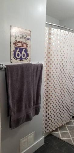 a bathroom with two towels and a sign on the wall at BLUE FLAMINGO'S CHARMING HOME-Heart of Tulsa2- Cherry St-Expo-11th in Tulsa