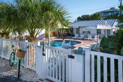 une clôture blanche avec une piscine dans la cour dans l'établissement Silver Sands, à St. Pete Beach