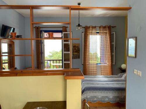 um quarto com uma cama e uma janela em Panorama Apartments em Marathokampos