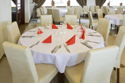 a dining room with a white table with red napkins at Hotel Zieleniec in Zieleniec
