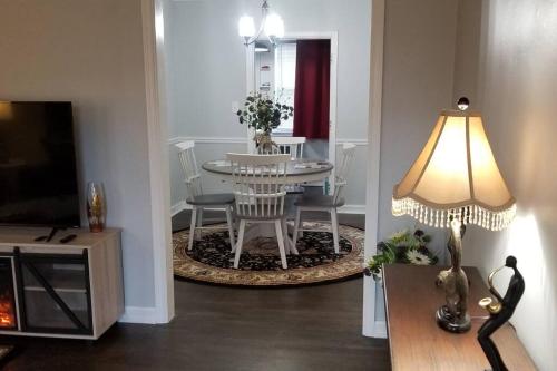 a living room with a table and chairs and a lamp at BLUE FLAMINGO'S CHARMING HOME-Heart of Tulsa2- Cherry St-Expo-11th in Tulsa