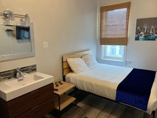 Dormitorio pequeño con cama y lavamanos en Commercial Hotel, en Edmonton