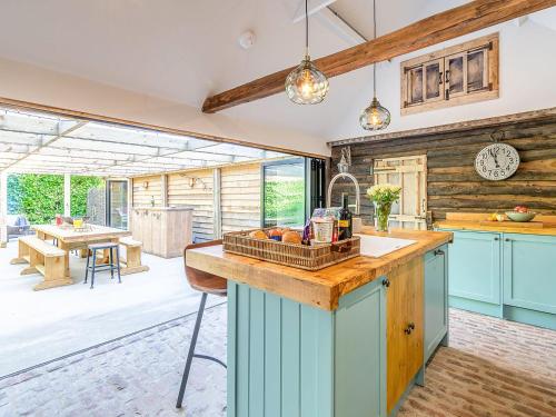uma cozinha com armários azuis e uma bancada em Old Shires Barn em Norton