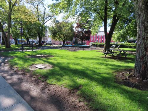 a park with benches and trees in the grass at St Charles Hotel Downtown Hudson in Hudson