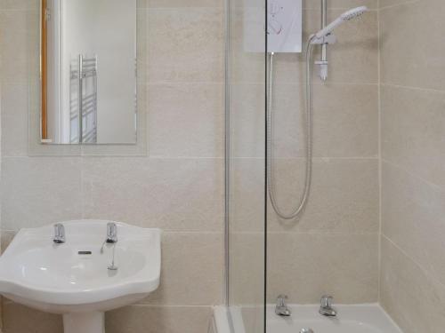 a bathroom with a shower and a sink and a toilet at Thistle Cottage in Glanton