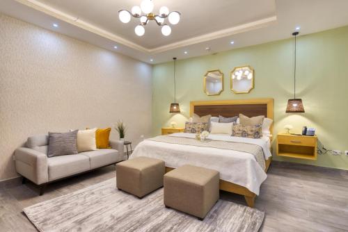 a bedroom with a bed and a couch and a chair at Melina Hotel in Higuey