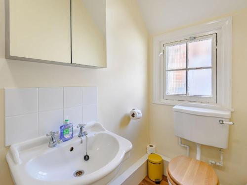 a bathroom with a sink and a toilet and a window at Top Flat-uk35142 in Lincoln