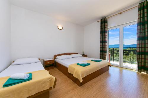a bedroom with two beds and a large window at Apartments with a parking space Gradac, Makarska - 14708 in Gradac
