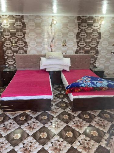 two beds are sitting in a room with tiles at Nubian Dreams Guest House in Aswan