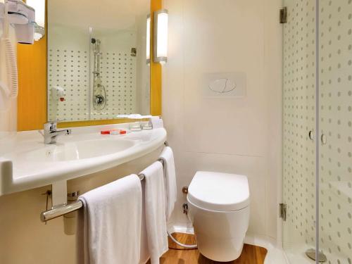 クタにあるアイビス バリ クタのバスルーム(洗面台、トイレ、鏡付)