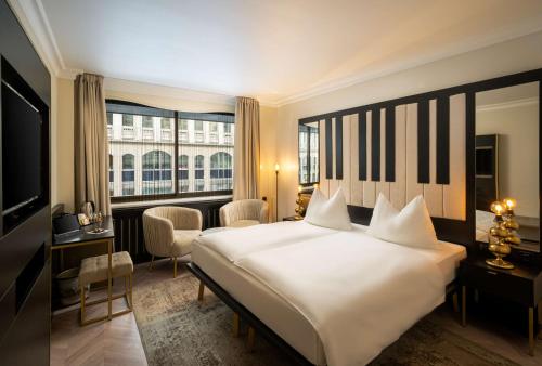 a hotel room with a large bed and a large window at Arthotel ANA Amadeus in Vienna