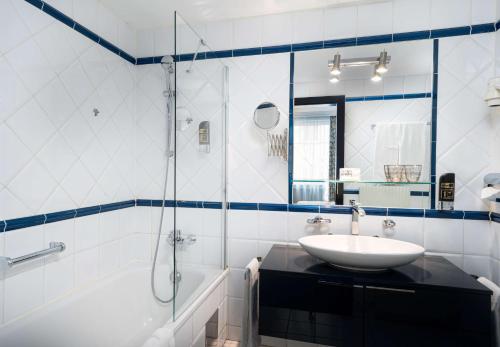 a white bathroom with a sink and a shower at Arthotel ANA Gala in Vienna