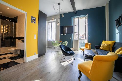 - un salon avec des murs jaunes et bleus et un canapé dans l'établissement The Loft - Superb 2 bedrooms on top floor with terrace - 10min to Palais & Beach!, à Cannes