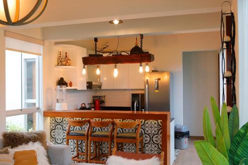 een keuken met een bar met 2 stoelen in een kamer bij Kuyayky Lodge in Lima