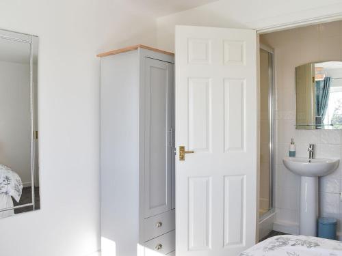 een badkamer met een witte deur en een wastafel bij Wesley Old Hall House in Bacup