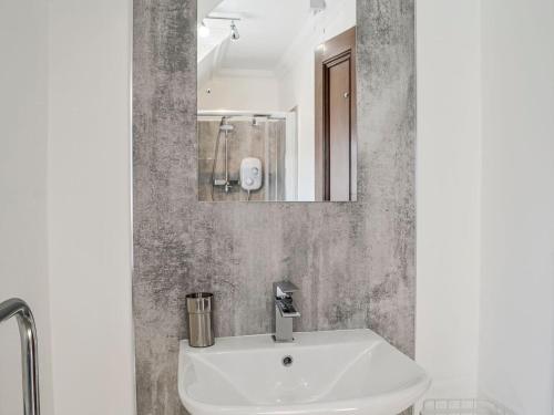 a bathroom with a white sink and a mirror at Repentance View in Carrutherstown