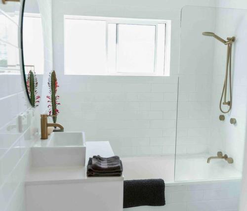a white bathroom with a sink and a shower at Paradise 31 - Pink oasis in the heart of the GC in Gold Coast
