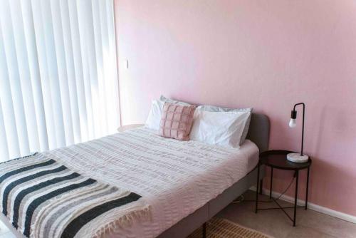 a bedroom with a bed with a pink wall at Paradise 31 - Pink oasis in the heart of the GC in Gold Coast