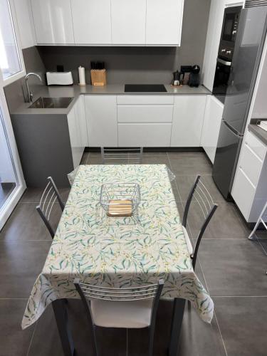 雷東德拉的住宿－Apartamento vacacional，带桌子和椅子的厨房以及带柜台的厨房