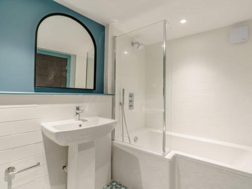 a white bathroom with a sink and a shower at Frenchgate Mews in Richmond