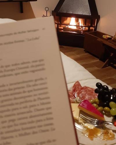 a plate of food on a bed with a menu at Chale Vale Encantado in São Bento do Sapucaí