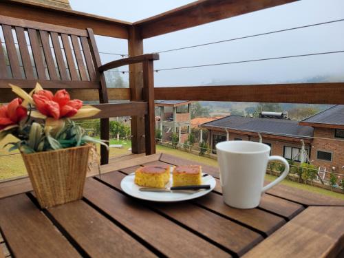 a plate of cake and a cup of coffee on a table at Chale Vale Encantado in São Bento do Sapucaí