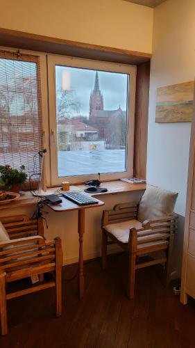 a room with a desk and a window with a keyboard at Cozy Studio in Palanga City Center in Palanga