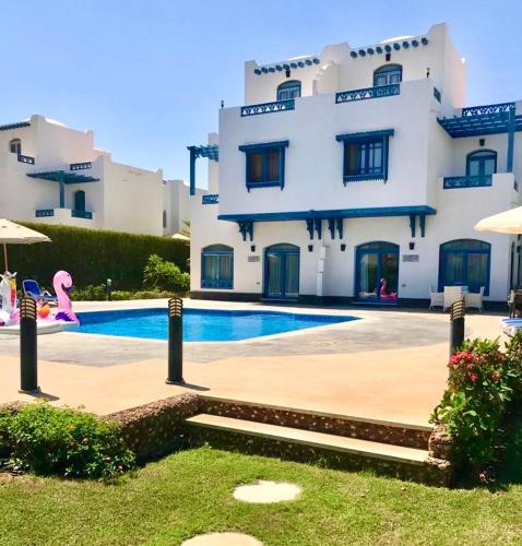 a large building with a swimming pool in front of it at Luxury Villa with pool in Hurghada in Hurghada