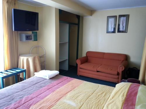 Habitación de hotel con cama y sofá en Coca House, en Arequipa