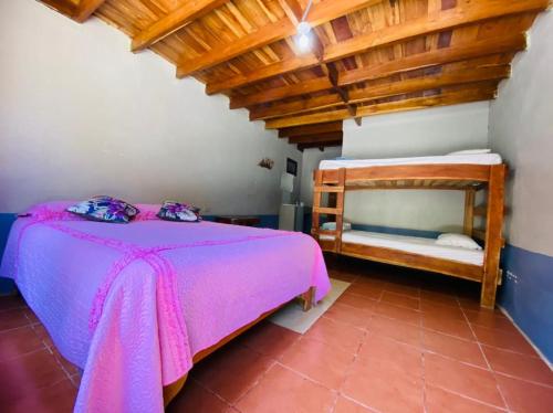 1 dormitorio con cama y techo de madera en Hostel La Suerte, en Monteverde