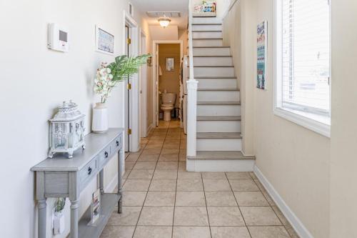a hallway with a tile floor and stairs at Seaview Duplex 7 in Kure Beach
