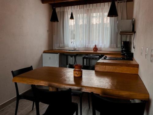 a kitchen with a wooden table and some chairs at Chale Vale Encantado in São Bento do Sapucaí