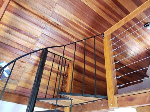 a wooden staircase in a room with a wooden ceiling at Chale Vale Encantado in São Bento do Sapucaí