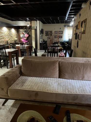 a couch in a living room with tables and chairs at Garni Hotel City in Kruševac