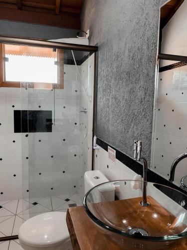 a bathroom with a sink and a toilet at Chale Vale Encantado in São Bento do Sapucaí
