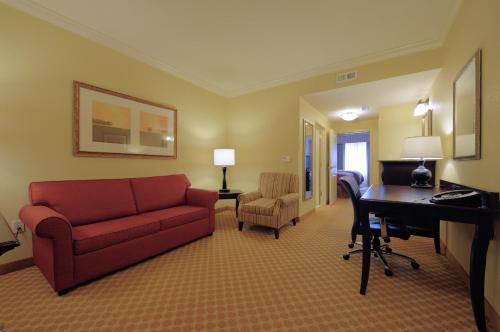 a living room with a red couch and a desk at Country Inn & Suites by Radisson, Columbia at Harbison, SC in Columbia