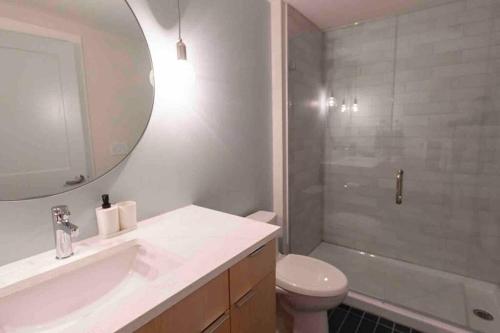 a bathroom with a sink and a toilet and a shower at Spacious 2 bed 2 bath Downtown OTR condo minutes walk to the Reds Bengals stadium & more! in Cincinnati