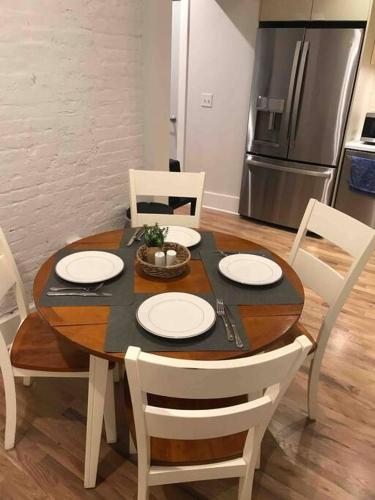 a dining room table with white chairs and a kitchen at Spacious 2 bed 2 bath Downtown OTR condo minutes walk to the Reds Bengals stadium & more! in Cincinnati