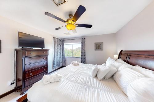 um quarto com uma cama grande e uma ventoinha de tecto em Everything at Your Fingertips em Phoenix
