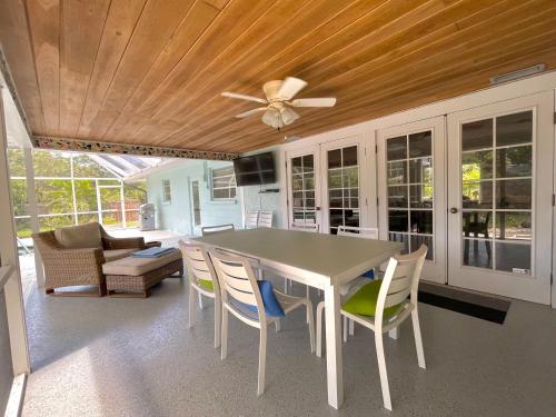 a dining room table with chairs and a ceiling fan at Clematis House near Arlington Park with Heated Pool in Sarasota