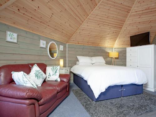 a bedroom with a bed and a couch in a room at Mallard Roundhouse - Uk33891 in Cullompton