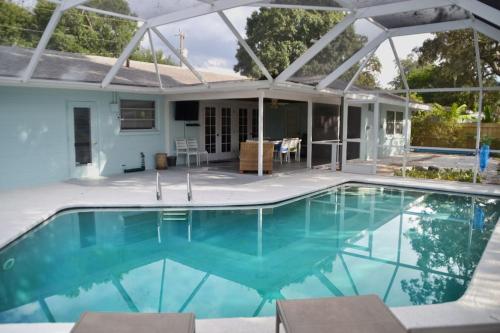 una piscina con una casa sullo sfondo di Clematis House near Arlington Park with Heated Pool a Sarasota