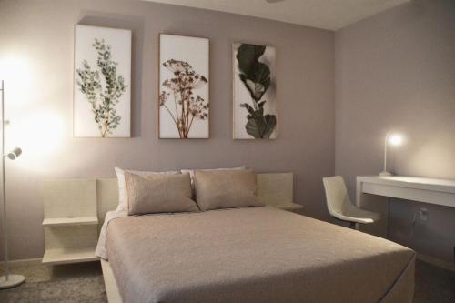 a bedroom with a bed and three paintings on the wall at Clematis House near Arlington Park with Heated Pool in Sarasota