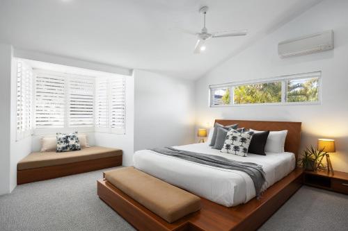 a bedroom with a large bed and two windows at Villa Bianco, 5 Key Court, Noosa Heads in Noosa Heads