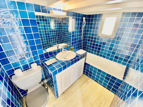 La salle de bains est pourvue de carrelage bleu, d'un lavabo et de toilettes. dans l'établissement Èrsextius, IB, Aix-en-Provence, à Aix-en-Provence