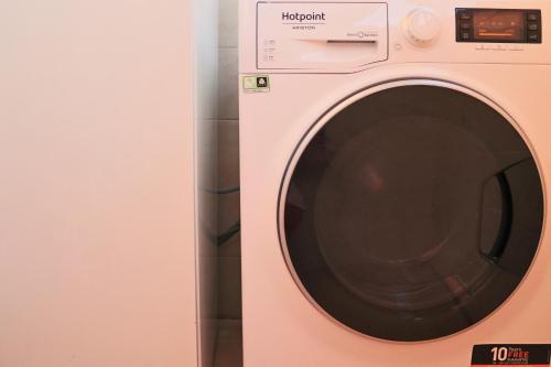 a pink washing machine sitting next to a wall at Сomfortable apartments and free garage parking in Porto