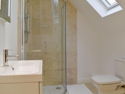 y baño con ducha, aseo y lavamanos. en The New Inn Barn-uk31813 en Marnhull
