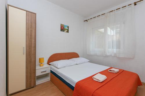 a small bedroom with a bed and a mirror at Apartments with parking space Gradac, Makarska - 5198 in Gradac