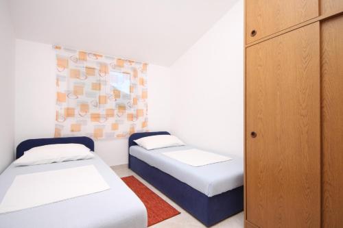 a room with two beds and a cabinet at Apartments with a parking space Seget Vranjica, Trogir - 8507 in Seget Vranjica