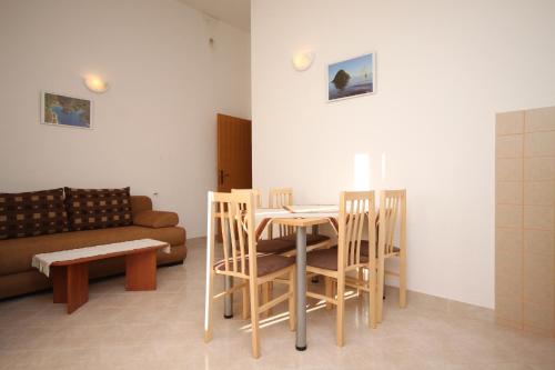 uma sala de estar com uma mesa e cadeiras e um sofá em Apartments with a parking space Seget Vranjica, Trogir - 8507 em Seget Vranjica